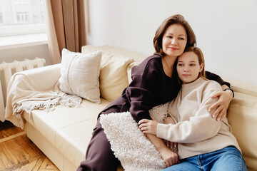 Portrait of mother and her young daughter student at home