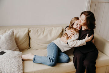 Teenage daughter affectionately hugging her mother