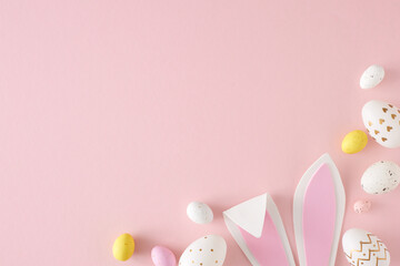 Easter celebration concept. Top view photo of yellow pink white eggs easter bunny ears on isolated...