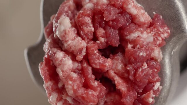 Macro shot of mincing meat in grinder. Cooking at home, kitchen appliance, healthy nutrition, hamburger ingredients