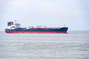 Oil tanker approaching a harbour on a cloudy summer day