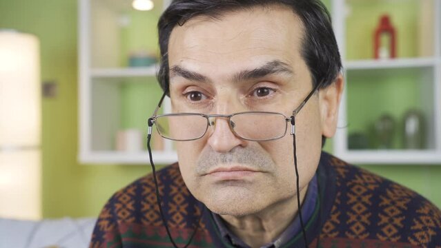Close-up of angry and grumpy old man twitching at home.
The stern and aggressive old man looks grumpy and hateful.
