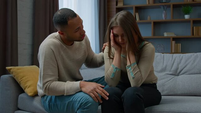 Guilty african american man apologizing to crying woman caring husband boyfriend calm sad stressed wife consoling girlfriend supporting saying sorry asking forgiveness after conflict family quarrel