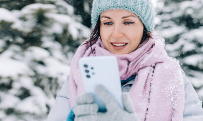 woman using smartphone in winter outdoors