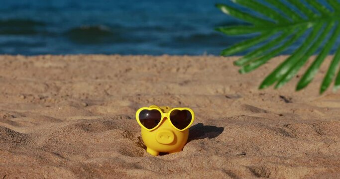 Yellow piggybank on the beach. Slow motion