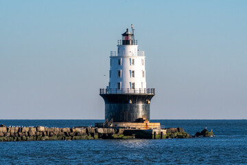The National Harbor of Refuge Light is a lighthouse built on the ocean end of the outer Delaware Breakwater at the mouth of the Delaware Bay, just off Cape Henlopen. - obrazy, fototapety, plakaty