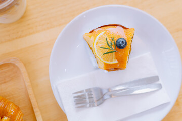 Top view piece of orange cake and sliced orange topping. Cake with orange mousse with copy space