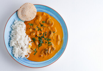 Curry sauce with rice and naan bread, in a blue plate, top view