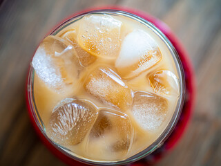 a cup of coffe filled with ice cubes,close up top shot. Refreshing summer drink