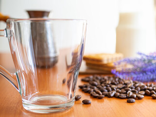 empty glass next to a pile of coffee beans, Cookies and milk bottle on background