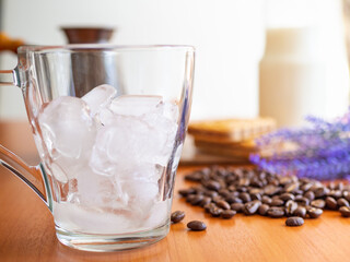 a glass of ice and coffee beans on a table, Cookies and milk bottle on background