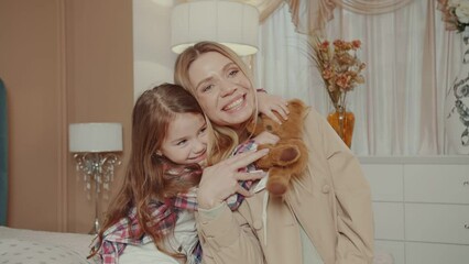 Portrait of a mother lovingly embracing her daughter.  Mother's Day concept.