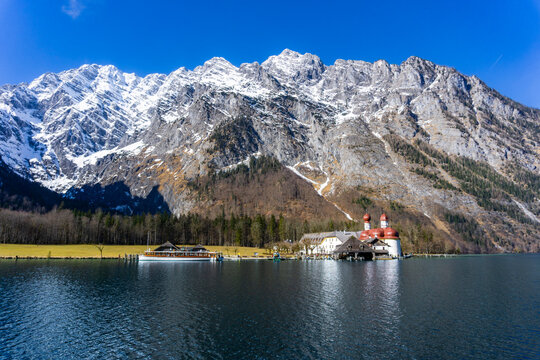 Urlaub in Bayern: der schöne Königssee im Berchtesgadener Land, Alpen mit der Wallfahrtskirche St. Bartholomä im Winter bei Schnee