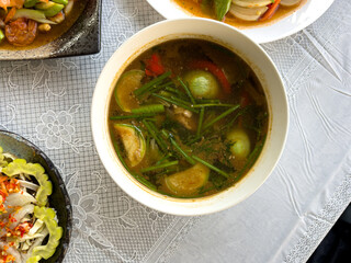 Thai curry ,local food,Northern Thai Spicy Soup with Pork Giblets on the wooden table ready to eat.