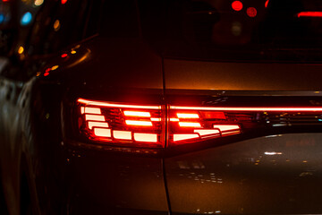 Red illuminated LED taillight on the back of a car at night
