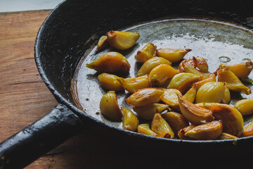 peeled fried or baked slices of garlic in an old pan without spices