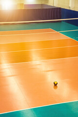 Sports image backdrop: volleyball net and ball in old empty sports gym, top view. Background for...