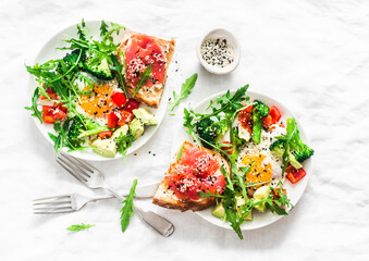 Delicious healthy breakfast - egg with vegetables, arugula salad and salmon cream cheese toast on a...