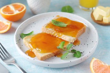 Sandwiches with marmalade, orange juice and coffee ready for breakfast