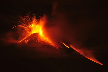 Night view of volcanic eruption showing lava fountains and streams flowing down the Etna sides in...