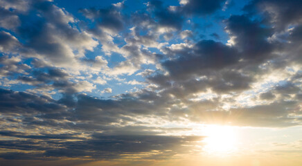Naklejka na ściany i meble Sunset with sun rays, sky with clouds and sun.