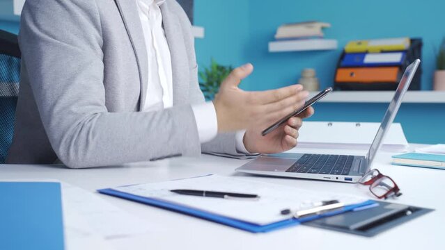 Close-up of angry businessman reacting to bad news.
Businessman working in the office gets angry at the bad news notification on his phone and throws the phone.
