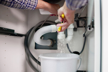 Male Plumber Repairing White Sink Pipe