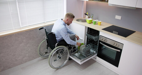 Person With Disability In Wheelchair Using Dishwasher
