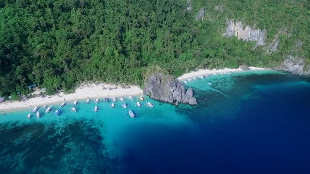 Seven Commandos and Papaya Beach in Palawan, Sightseeing Place. Tour A in El Nido, Philippines. Serene white sand beach with clear turquoise water, palm trees rock formations in Background