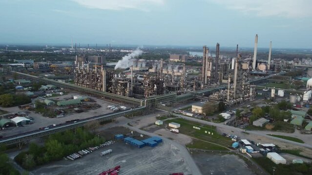 industry area with gas pipes and chimneys emit smoke which results emissions and pollution caused by the production factories and destroy environment – shot from above 