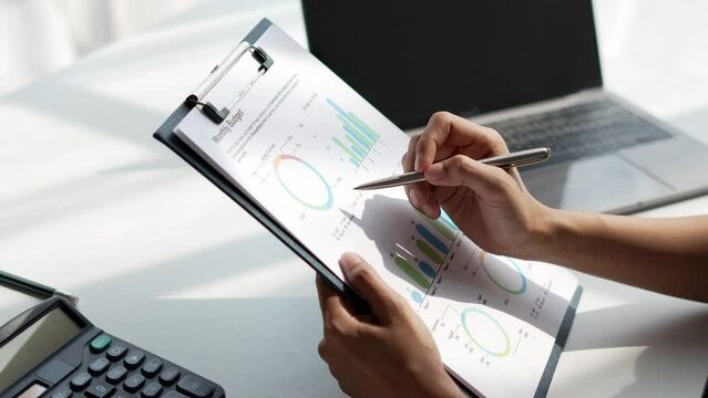 Business person analyzing financial statistics displayed on the financial report.