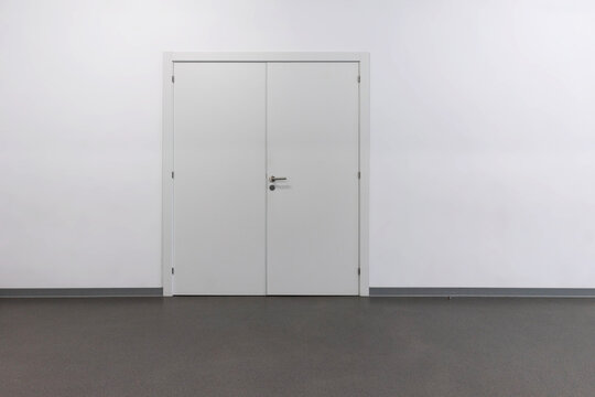 Lone white door on a blank wall