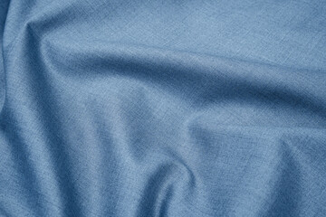 Fototapeta na wymiar Close-up of texture of plain silver blue fabric with folds. Abstract background of monochrome textile material for design and templates. Copy space.