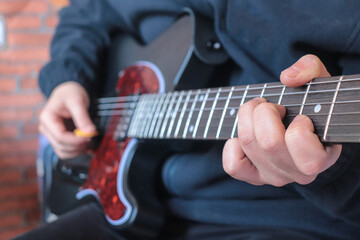 Man playing electric guitar at home