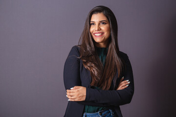 Horizontal photo. Beautiful Brazilian woman in casual clothes, black blazer jeans. Arms crossed.