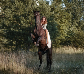 Beautiful girl riding a horse rearing up - 575415038