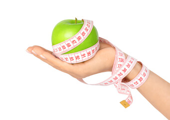 Female hand holding green apple wrapped with measuring tape isolated on transparent background. Weight loss and dieting concept