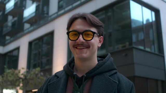 Portrait of handsome young man creative producer, manager. Young happy smiling cheerful guy university student standing near the office building laughing looking at camera. Headshot close up portrait.