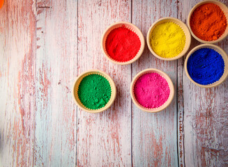 top view of colorful traditional holi powder in bowls isolated on dark background.Space for text . happy holi.Concept Indian color festival called Holi