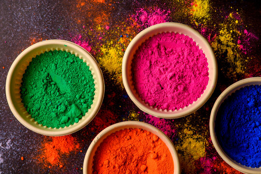top view of colorful traditional holi powder in bowls isolated on dark background.Space for text . happy holi.Concept Indian color festival called Holi © shouvik