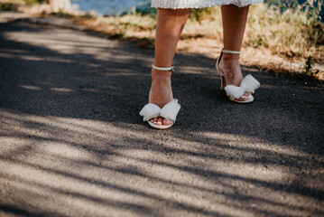 wedding details essentials white wedding dress bride in white robe getting ready for wedding day rings sandals heels sea sunset seaside 