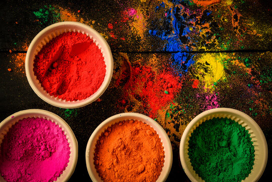 top view of colorful traditional holi powder in bowls isolated on dark background.Space for text . happy holi.Concept Indian color festival called Holi © shouvik