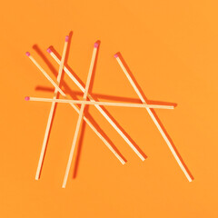 Matches on orange background. Top view.
