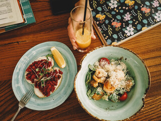 food flatlay. Caesar Salad. bruscheta with vegetables. juice