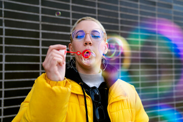 portrait with soap bubbles girl short blonde hair yellow coat sunlight