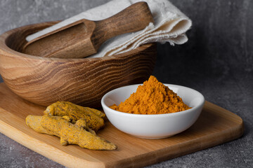 Turmeric powder and turmeric root. Curcumin, Curcuma longa Linn. Natural fabric dye, copy space.