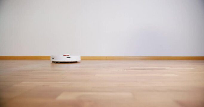 Robot vacuum cleaner performs automatic cleaning of the house at a certain time. Smart home concept. Copy space