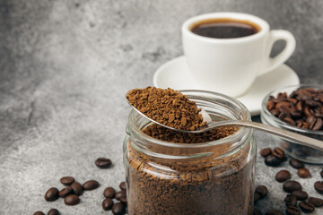Ingredients for making coffee - coffee beans, ground and instant coffee on a black textured background. Caffeine. Decaffeinated coffee. Aroma energy hot drink. Place for text, space for copy.