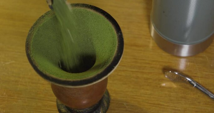Pouring yerba mate in the bowl. Mate or chimarrao is an typical drink of the gauchos