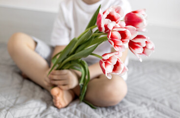 tulips on jeans and spring calling on smartphone.slide to answer incoming call.kid holding bouquet of flowers wrapped in paper on window sill.easter holiday origami rabbit mother women day march 8th